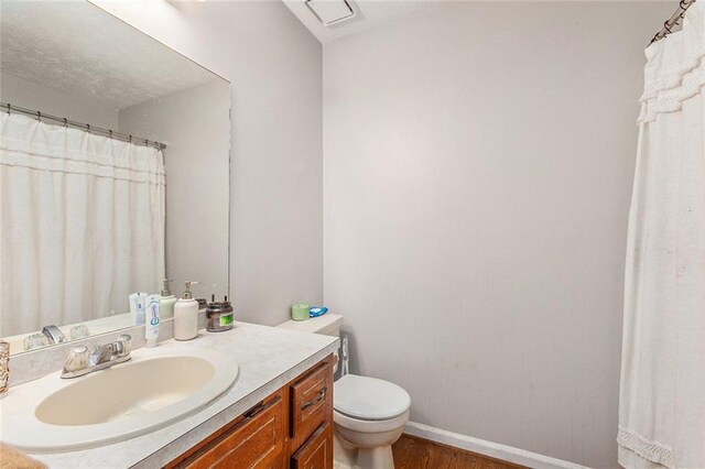 bathroom featuring toilet, vanity, and wood-type flooring