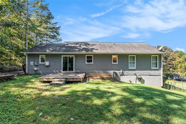 rear view of house with a yard and a wooden deck