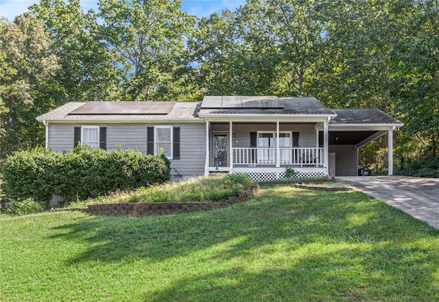 ranch-style home featuring a carport, a front yard, solar panels, and covered porch