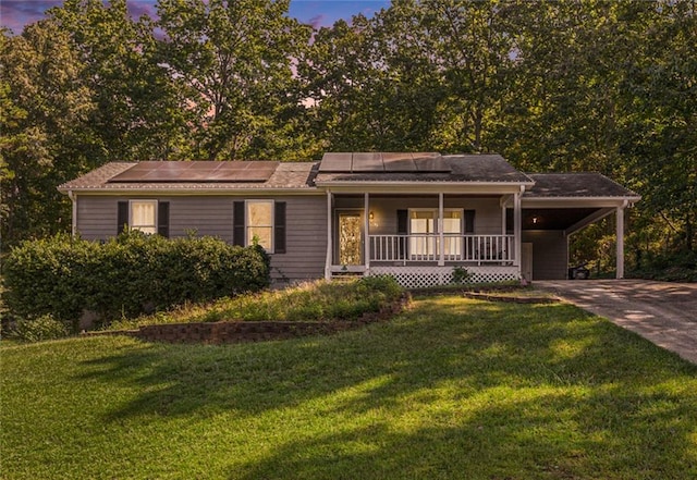 view of front of home with a carport, a porch, and a lawn