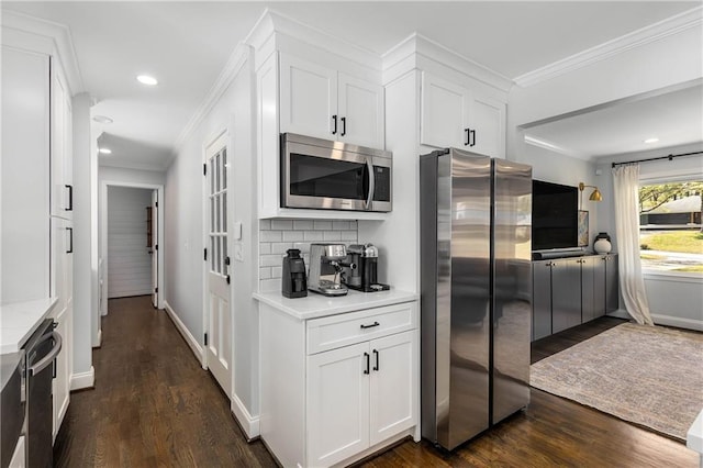 1055 Delmont Ter, Roswell, GA 30075 - kitchen with stainless steel appliances, light countertops, dark wood-style flooring, ornamental molding, and white cabinets