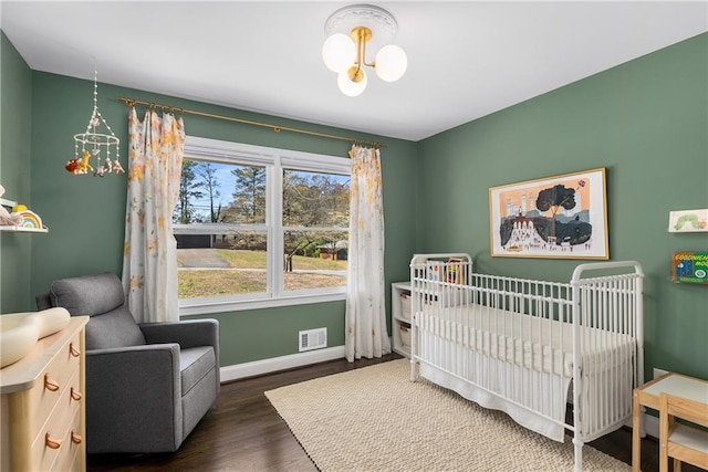 1055 Delmont Ter, Roswell, GA 30075 - bedroom with a crib, wood finished floors, and baseboards