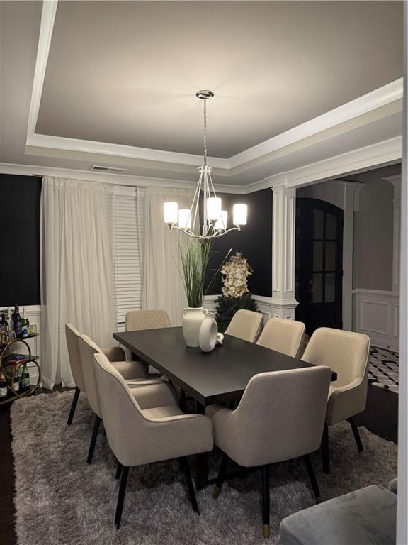 2709 Ratby Ln NE, Conyers, GA 30013 - dining space featuring a raised ceiling, a chandelier, a decorative wall, ornamental molding, and wainscoting