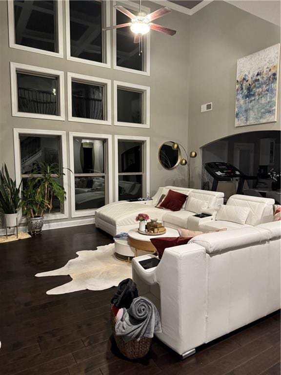 2709 Ratby Ln NE, Conyers, GA 30013 - living area featuring dark wood finished floors, crown molding, a towering ceiling, and a ceiling fan