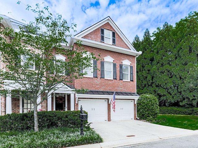 view of front of property featuring concrete driveway, brick siding, an attached garage, and a standing seam roof