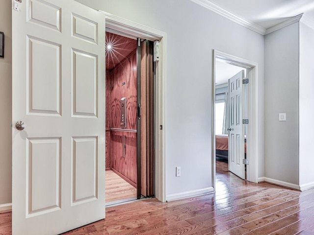 unfurnished bedroom featuring crown molding, wood finished floors, baseboards, and a closet
