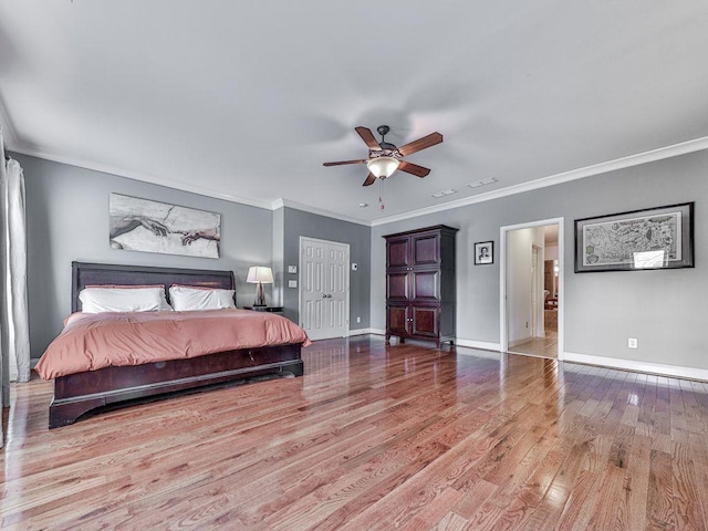 bedroom with wood finished floors, baseboards, ornamental molding, and a ceiling fan