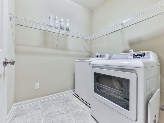 washroom featuring separate washer and dryer and baseboards