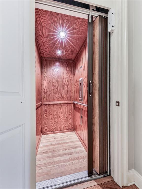 elevator featuring wood finished floors