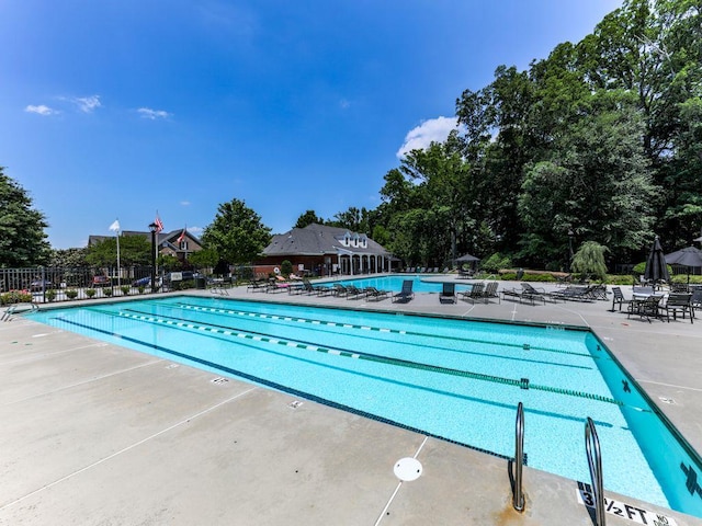 community pool featuring fence and a patio area