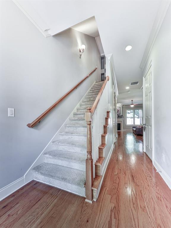 stairway with ornamental molding, wood finished floors, baseboards, recessed lighting, and a ceiling fan