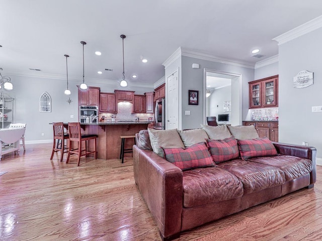 living area featuring light wood finished floors, recessed lighting, baseboards, and ornamental molding