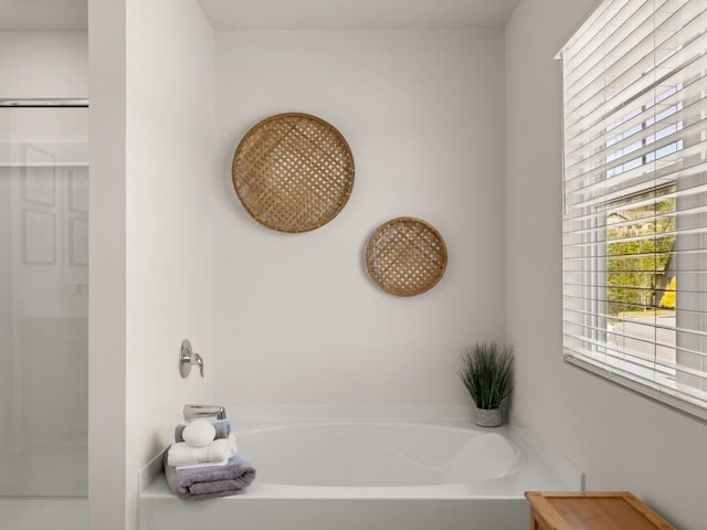bathroom featuring a shower and a bath