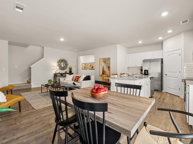dining area featuring stairs, recessed lighting, wood finished floors, and baseboards