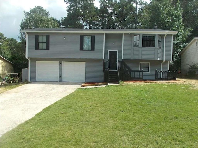 bi-level home with a front yard, concrete driveway, and a garage