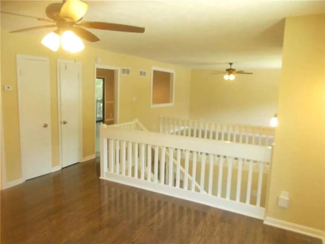 empty room featuring visible vents, wood finished floors, and a ceiling fan