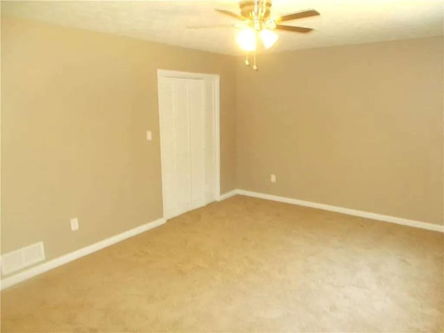 unfurnished room featuring baseboards, ceiling fan, and light colored carpet