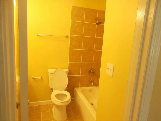 bathroom featuring tile patterned floors, toilet, baseboards, and washtub / shower combination