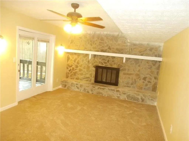 unfurnished living room with a ceiling fan, baseboards, a fireplace, and carpet