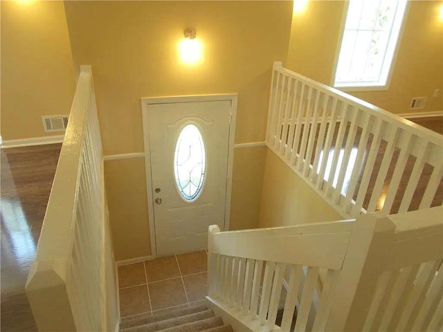 foyer entrance featuring visible vents and baseboards