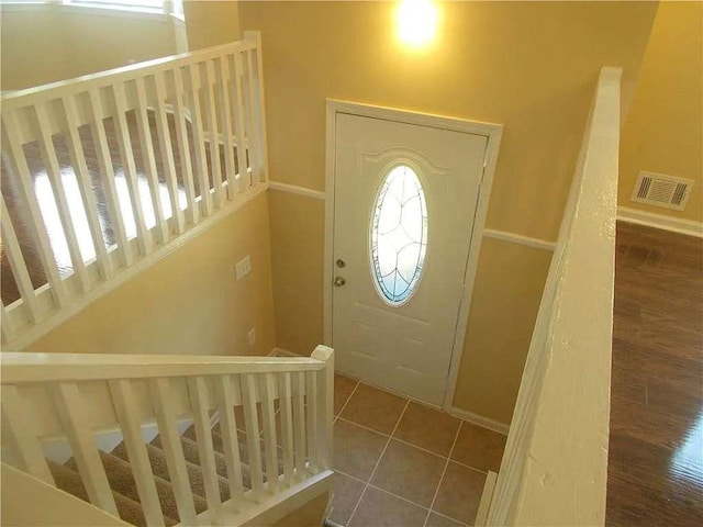 foyer with baseboards, stairs, a healthy amount of sunlight, and visible vents