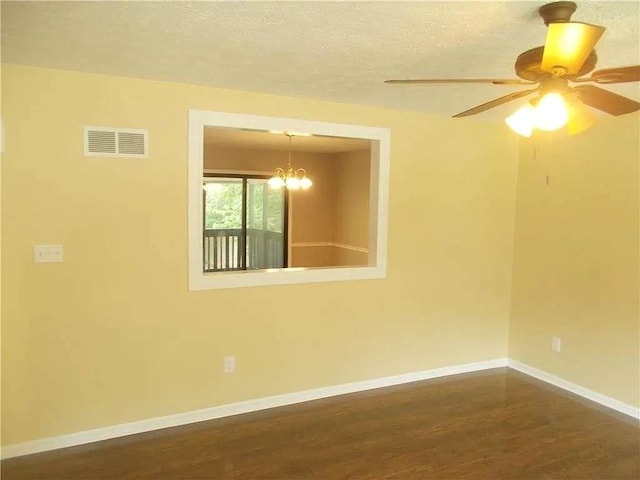 spare room featuring a textured ceiling, baseboards, dark wood-style flooring, visible vents, and ceiling fan with notable chandelier