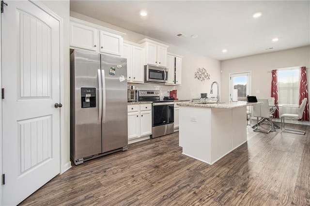 kitchen with sink, appliances with stainless steel finishes, a kitchen island with sink, white cabinetry, and dark hardwood / wood-style floors