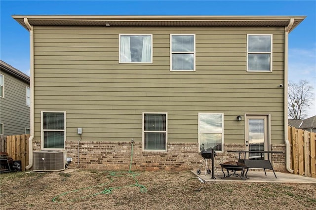 back of property with cooling unit, a fire pit, and a patio