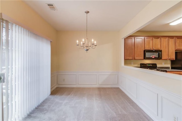 kitchen with visible vents, a notable chandelier, black appliances, plenty of natural light, and light colored carpet