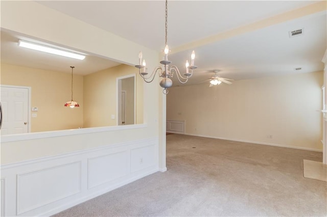 empty room featuring ceiling fan with notable chandelier, light colored carpet, visible vents, and baseboards