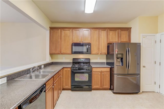 kitchen featuring brown cabinetry, black appliances, dark countertops, and a sink