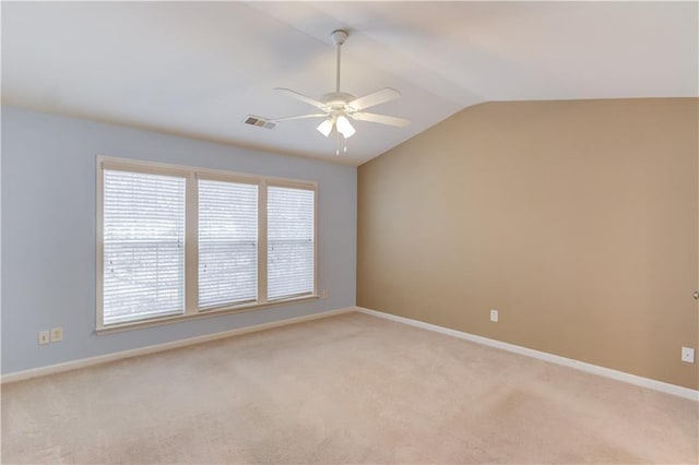 unfurnished room with light carpet, a ceiling fan, baseboards, and vaulted ceiling