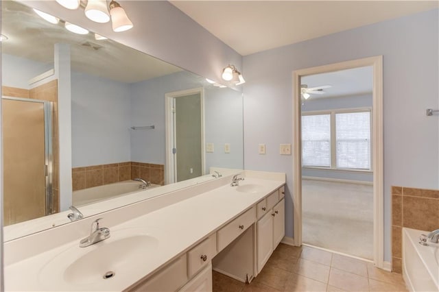 bathroom featuring a sink, a bath, double vanity, and tile patterned flooring