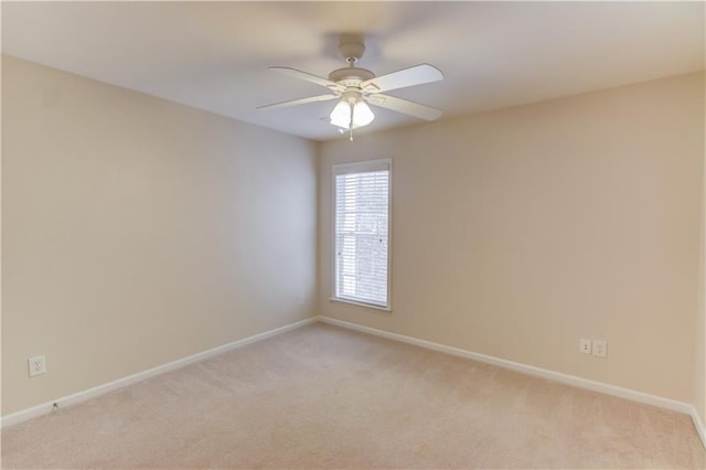 unfurnished room with a ceiling fan, baseboards, and light carpet