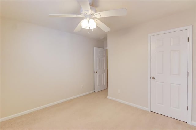 unfurnished bedroom featuring ceiling fan, baseboards, and light carpet