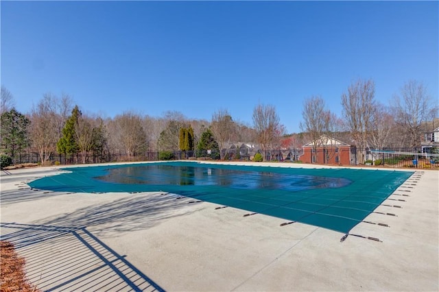 community pool with a patio and fence