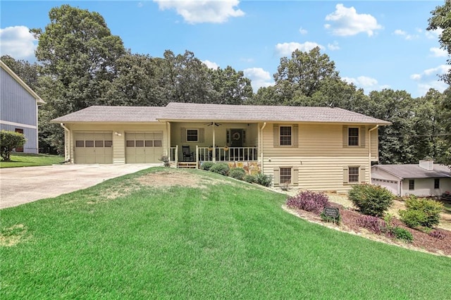 view of front of home featuring a garage, a front yard, and covered porch