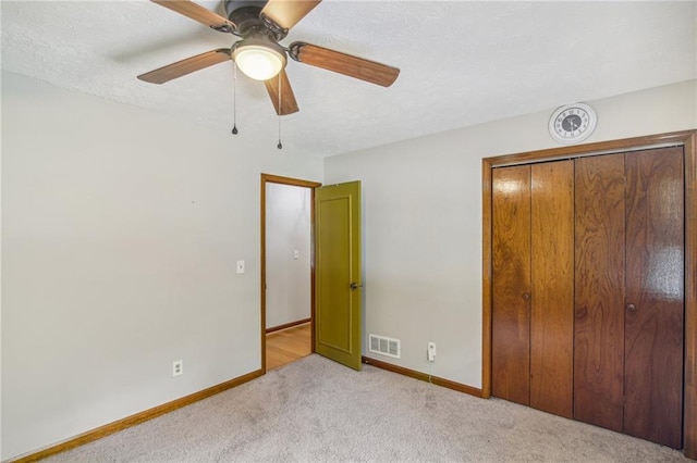 unfurnished bedroom with light carpet, a closet, and ceiling fan