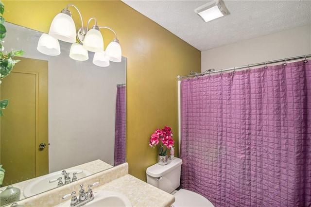 bathroom with sink, a textured ceiling, and toilet