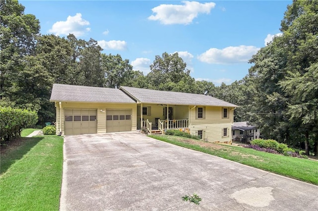 view of front of property with covered porch, a garage, and a front yard