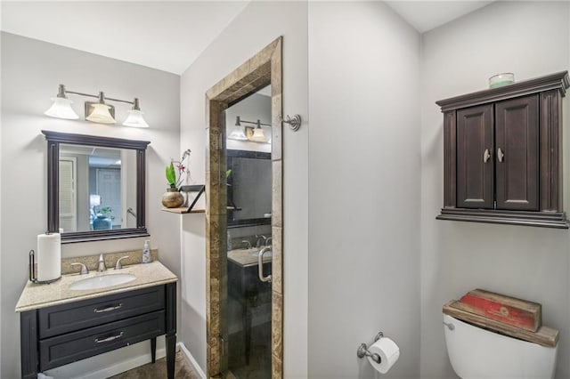 bathroom with vanity, toilet, and a shower with door