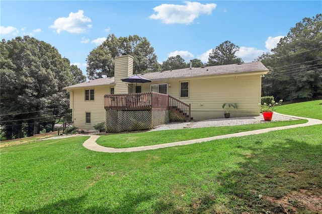 back of property with a deck and a yard