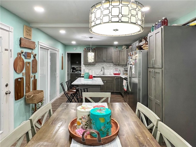 kitchen featuring dark hardwood / wood-style floors, stainless steel fridge, sink, and backsplash