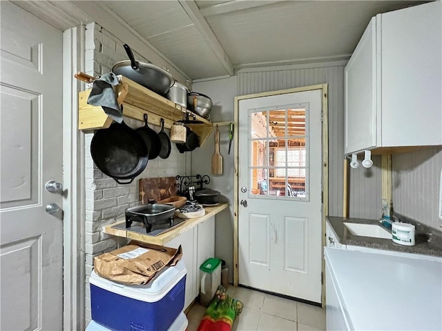 interior space featuring light tile patterned flooring, ornamental molding, and sink