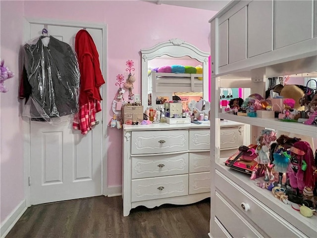 walk in closet with dark hardwood / wood-style flooring