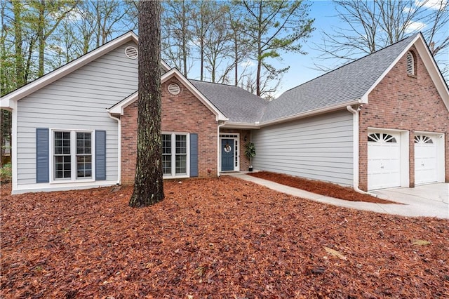 view of front of home featuring a garage, brick siding, roof with shingles, and driveway