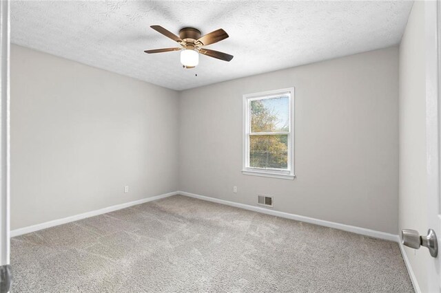 empty room with ceiling fan, carpet, and a textured ceiling