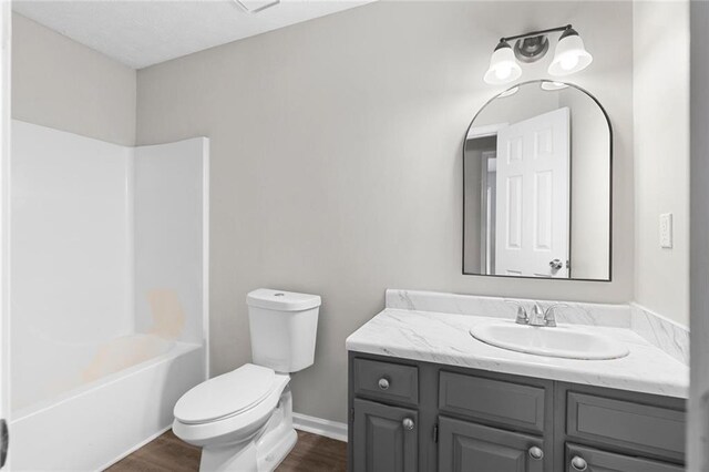 full bathroom featuring vanity, hardwood / wood-style flooring, toilet, and  shower combination