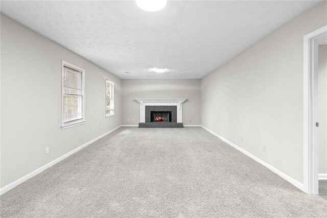 unfurnished living room featuring a tile fireplace and carpet