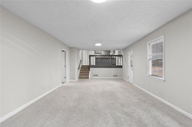 unfurnished living room with carpet and a textured ceiling